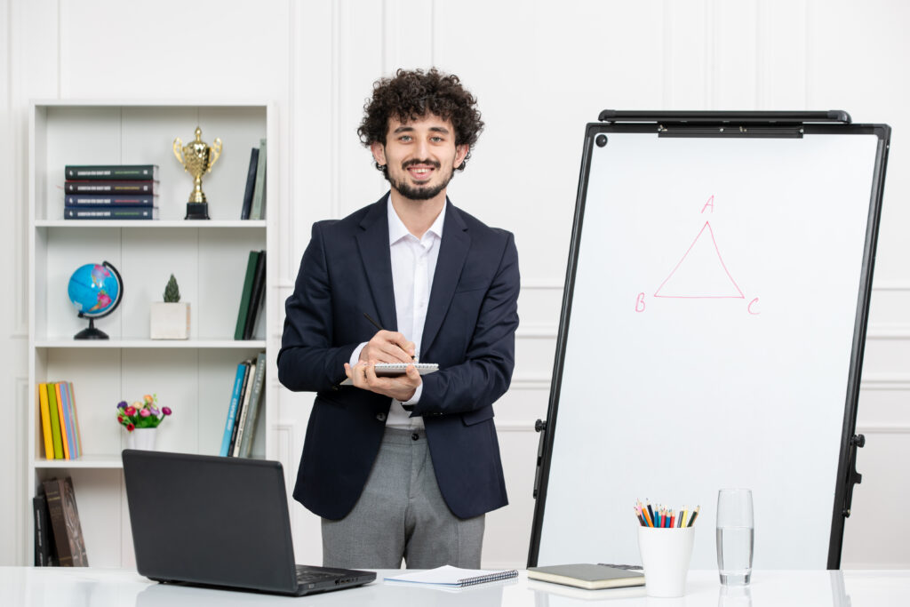 instructor-with-computer suit whiteboard classroom holding notepad